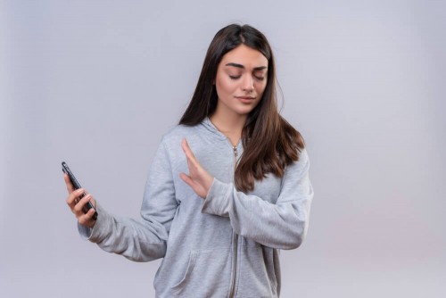 young-beautiful-girl-gray-hoody-holding-telephone-looking-telephone-standing-white-background9d30316bf9f0d073.jpg